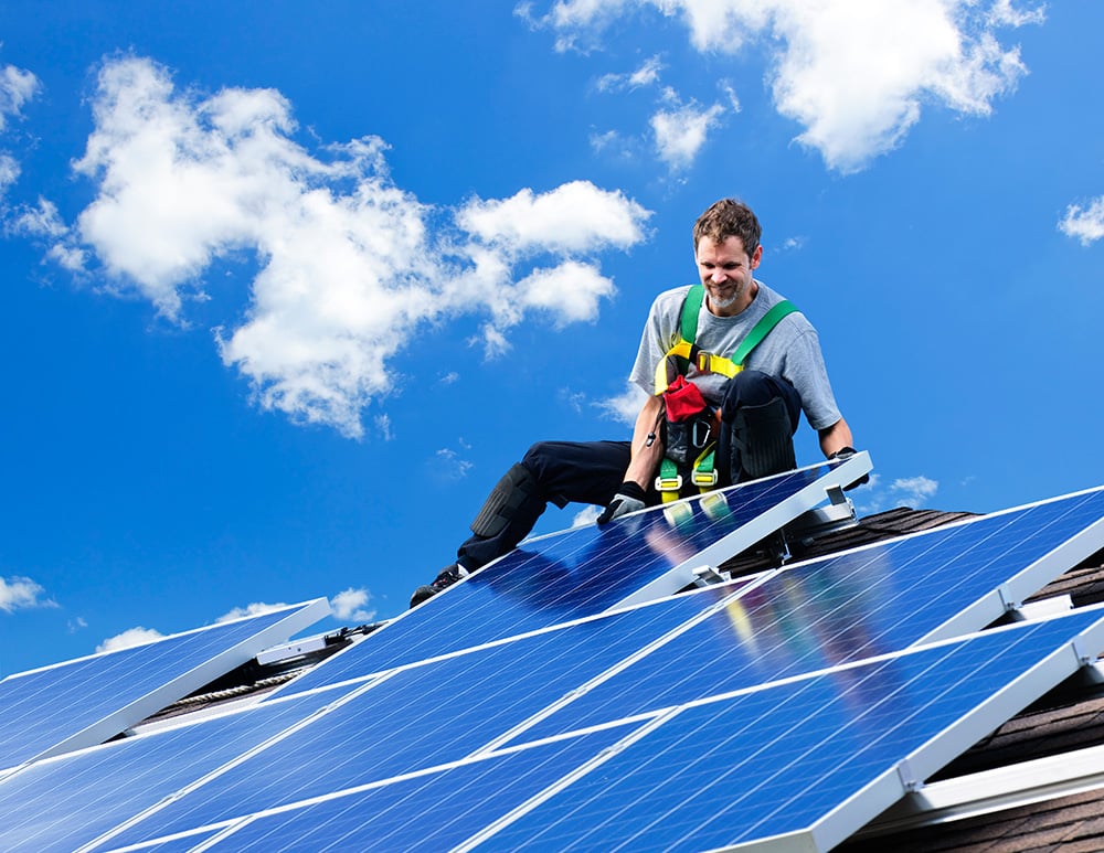 Solar contractor placing a Solar PV panel into place during installation process on a rooftop in Orlando Florida