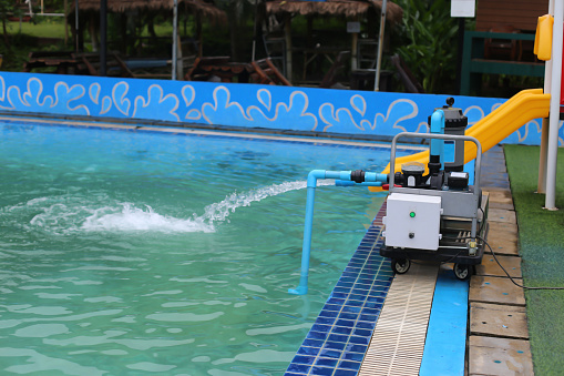 The water pump is pumping water into the pool.