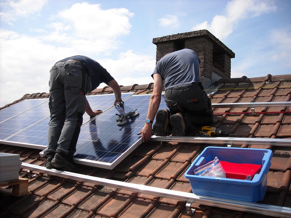 two solar contractors installing solar panels onto a slate roof in Orlando Florida